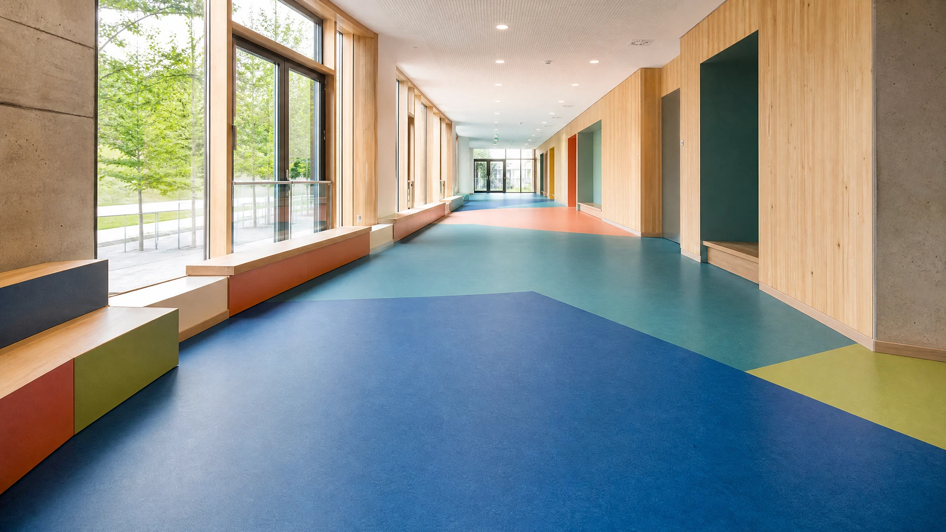 Illustratives Anwendungsbild eines farbigen elastischen Bodens in einem modernen Schulflur